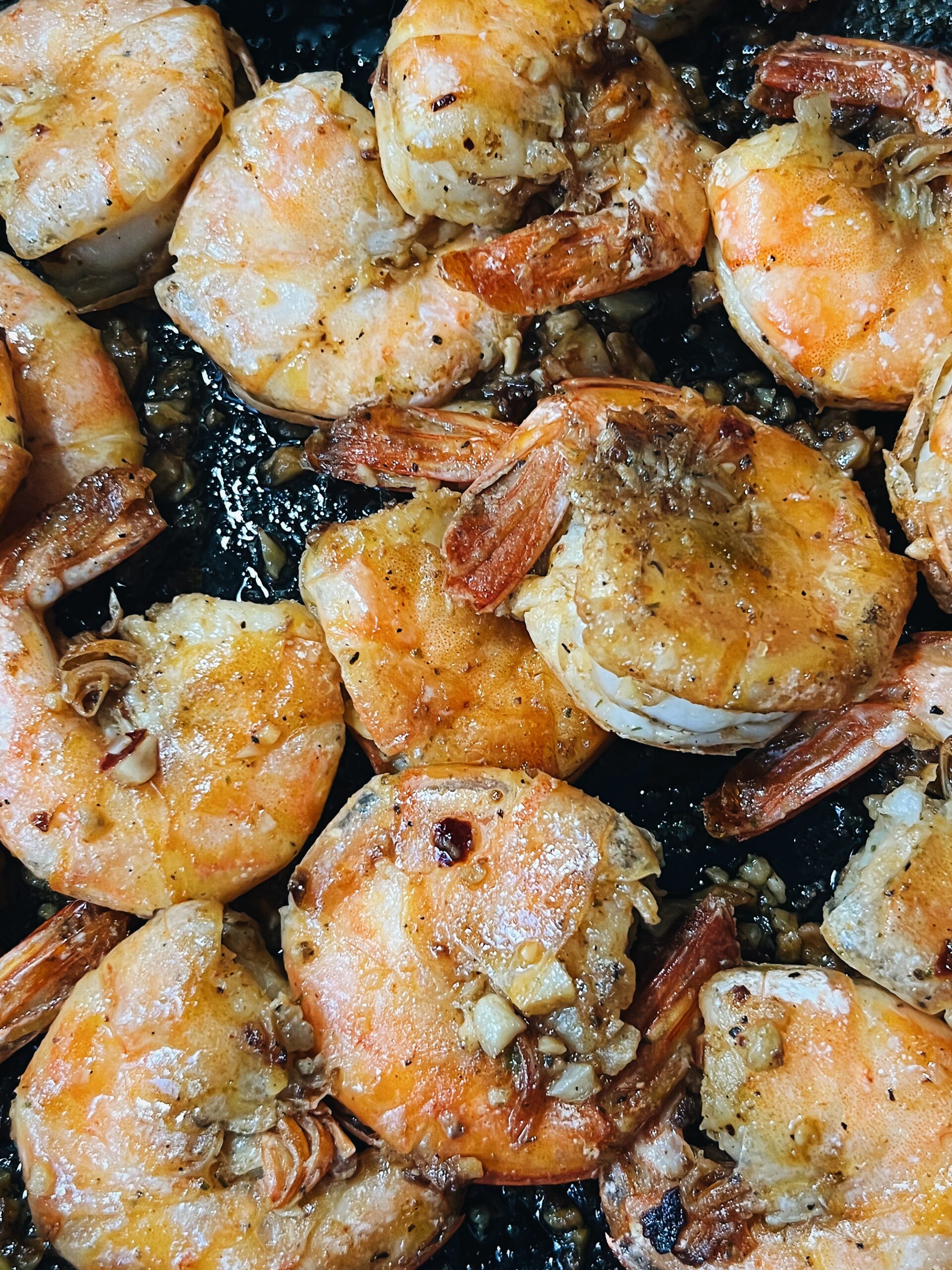 cooked shrimp with shell on, cooked with garlic in a hot skilled pan