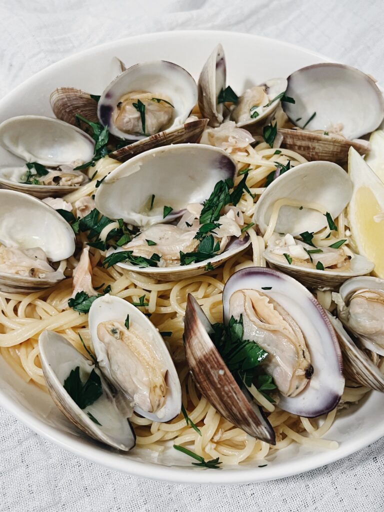 spaghetti alle vongole pasta with lemon and parsley in a bowl ready to be eaten